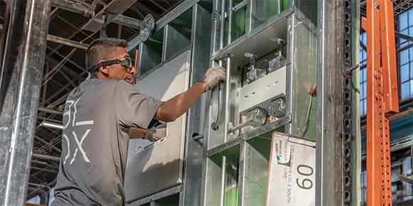 Man in goggles constructing a modular hospital